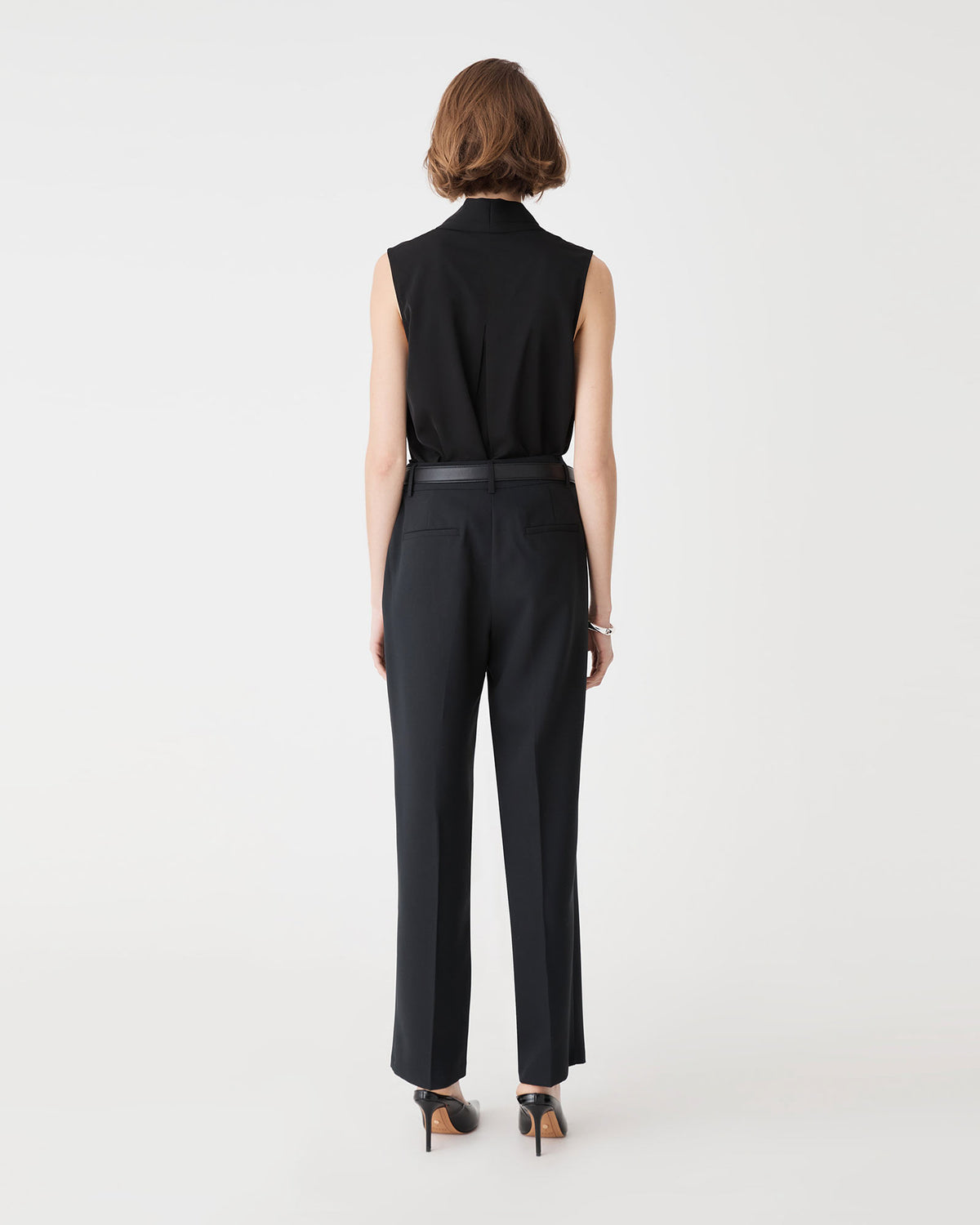 Back view of the black Alivia 2 V-Neck Top showing back tuck detail