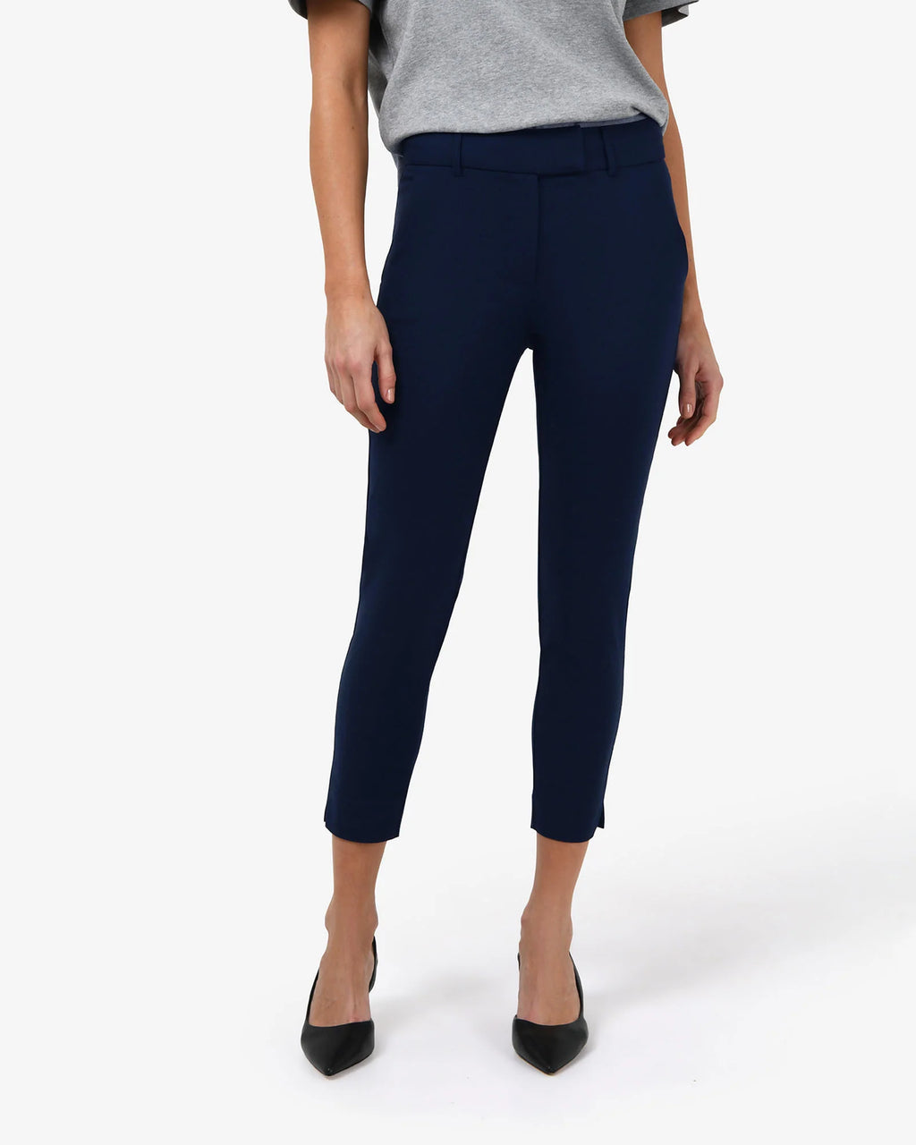 Front close view of the navy cropped pants showing waistband, belt loops and notched hem