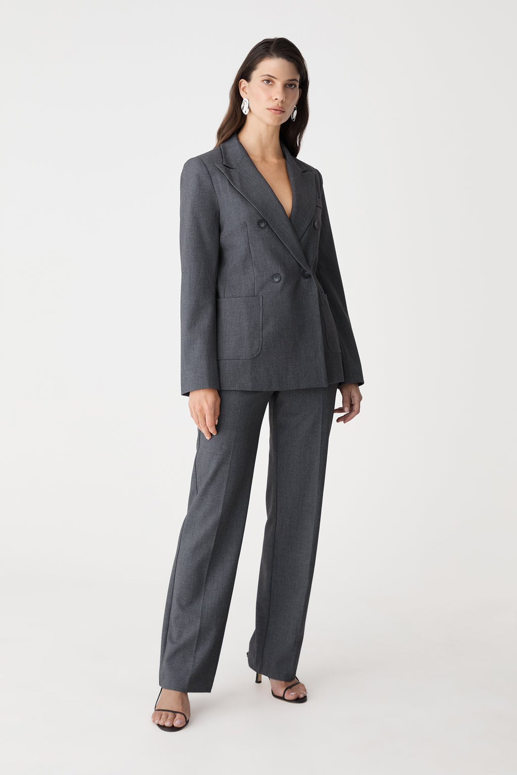 Side-front angle of the dark grey blazer and matching pants