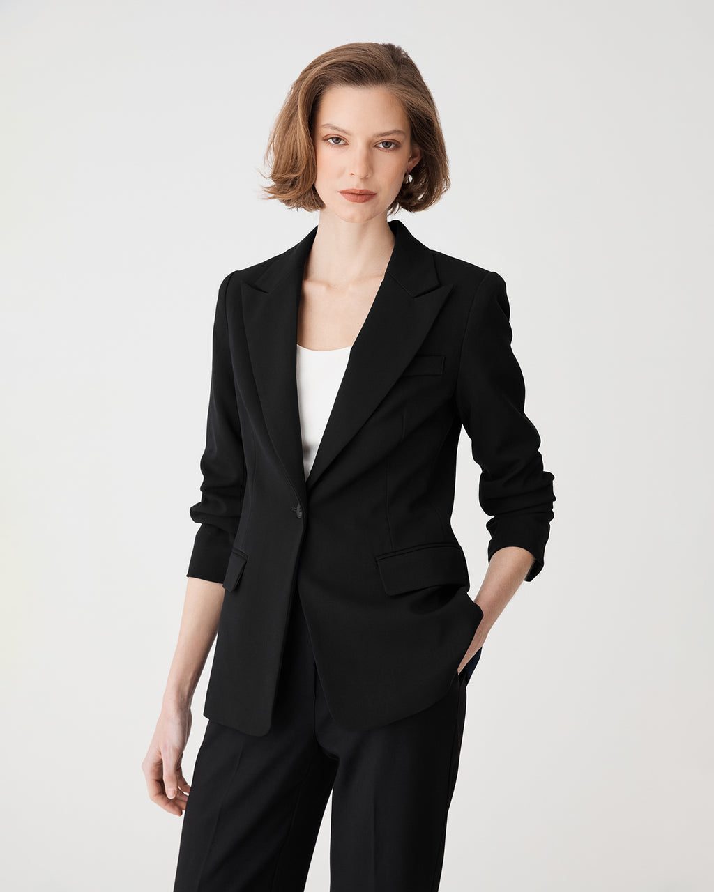 Front view, blazer buttoned with peak lapels and white top underneath