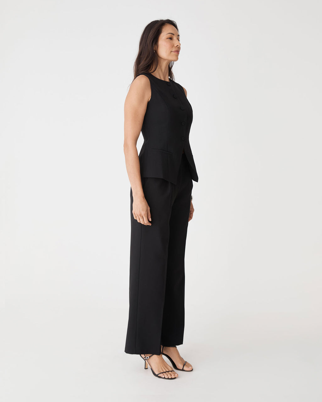 Side view of the black Nikki Tailored Pants worn with matching vest