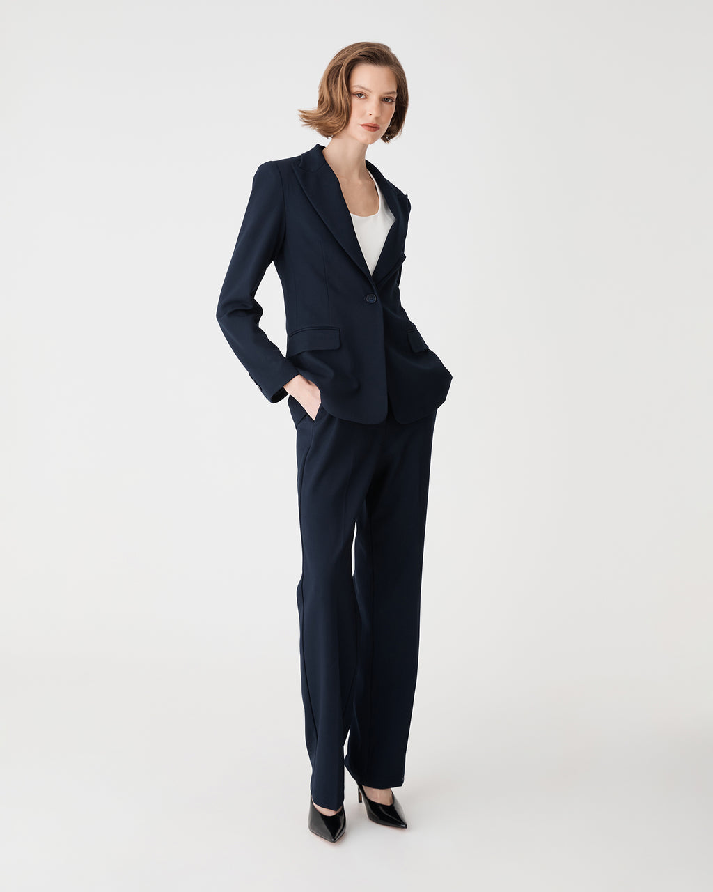 Side view of the navy Merid Tailored Pants with hand in side pocket