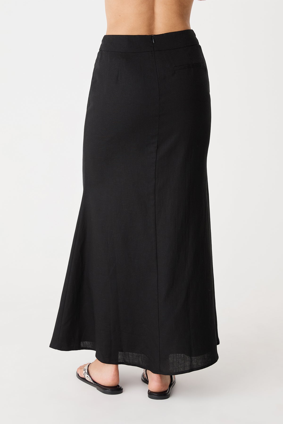 Back view of the black maxi skirt showing invisible back zipper and flared hem