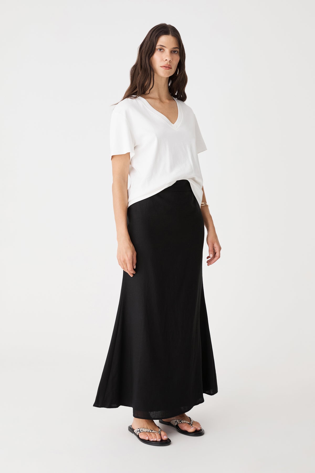 Side view of the black Amelia Linen Blend Maxi Skirt with white tee and black sandals