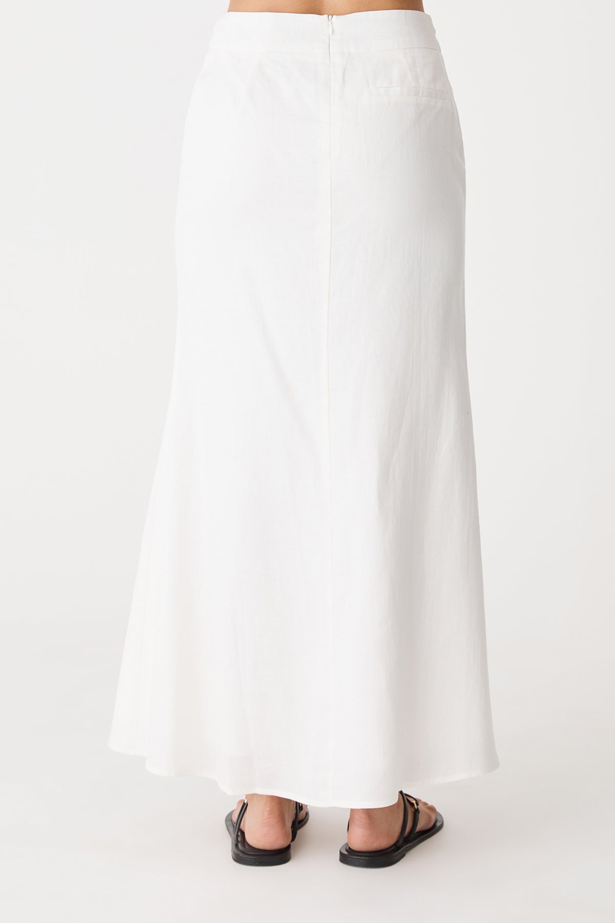 Back view showing the invisible zip and flared hem of the ivory maxi skirt