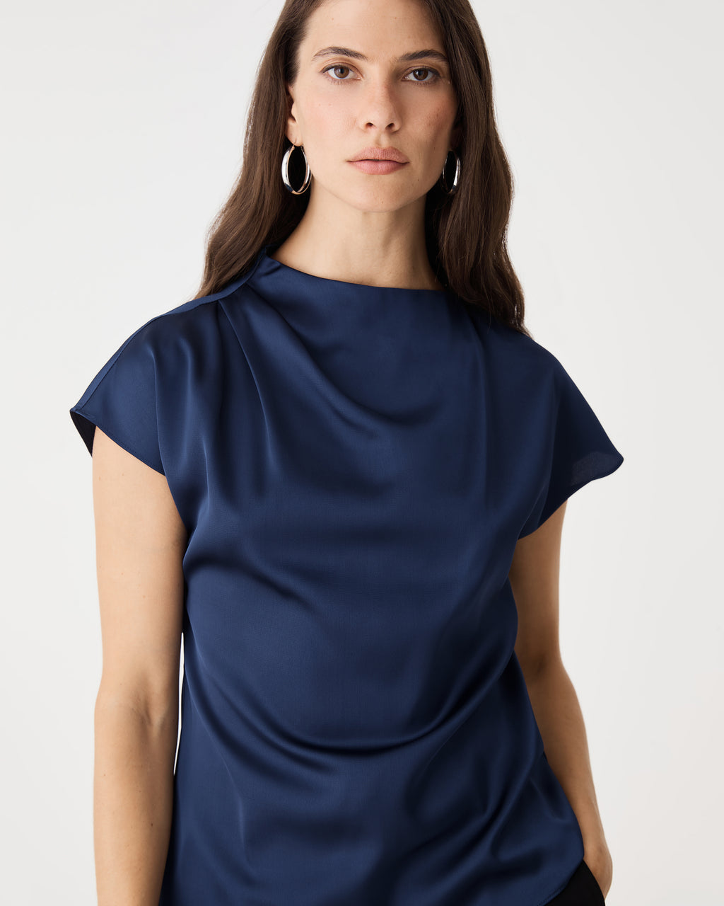 Close-up of the asymmetric pleated draped neckline in navy