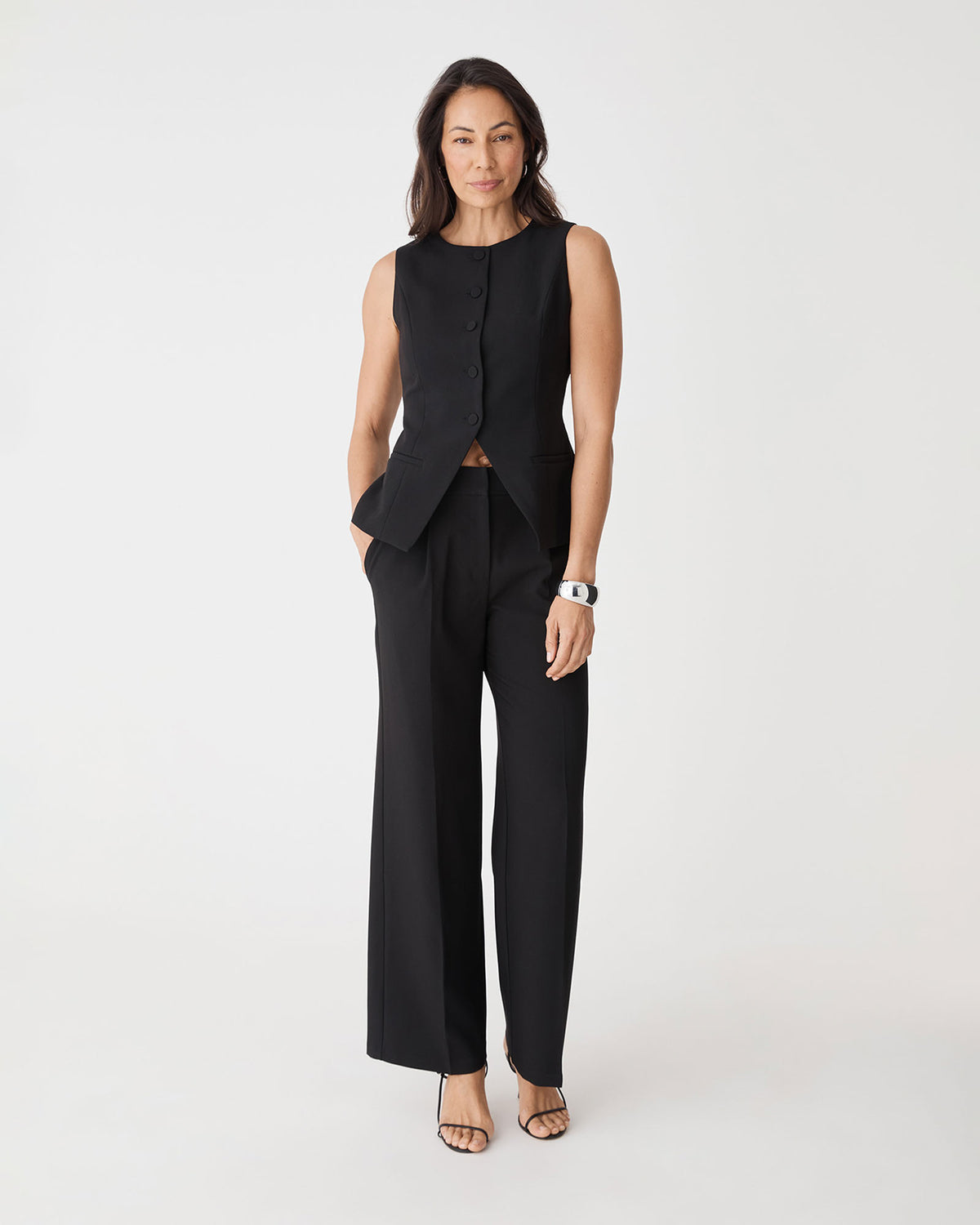 Front view of black Nikki Longline Vest worn with matching wide leg pants