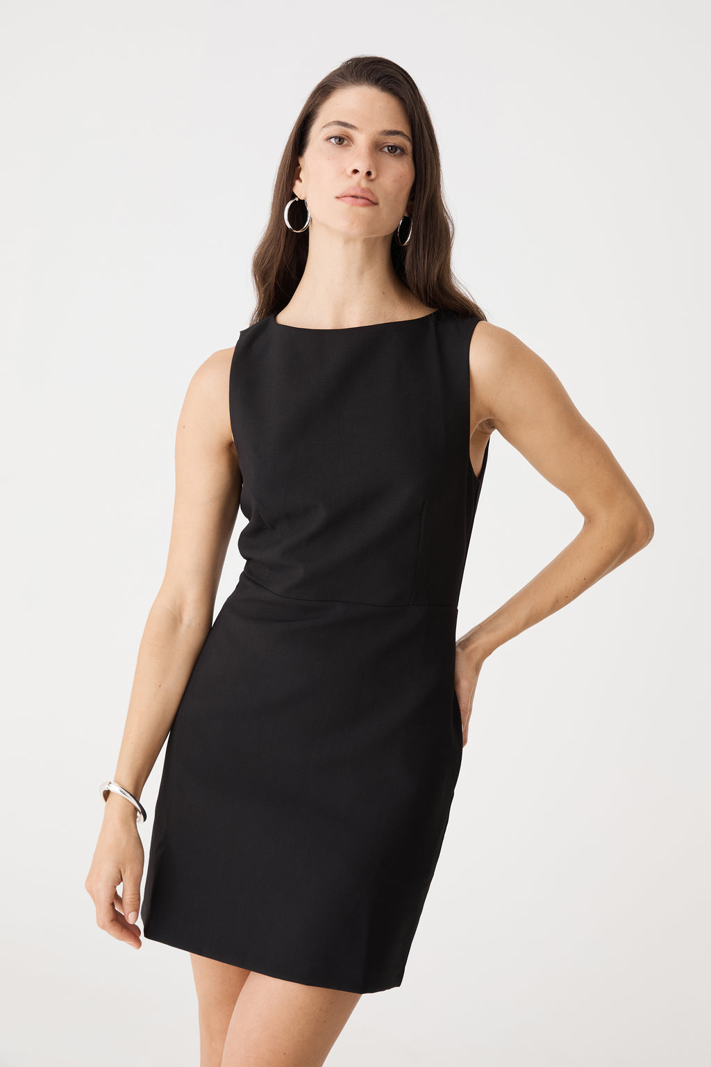 Front view cropped at the hip, showing boat neckline and fitted bodice of the black mini dress