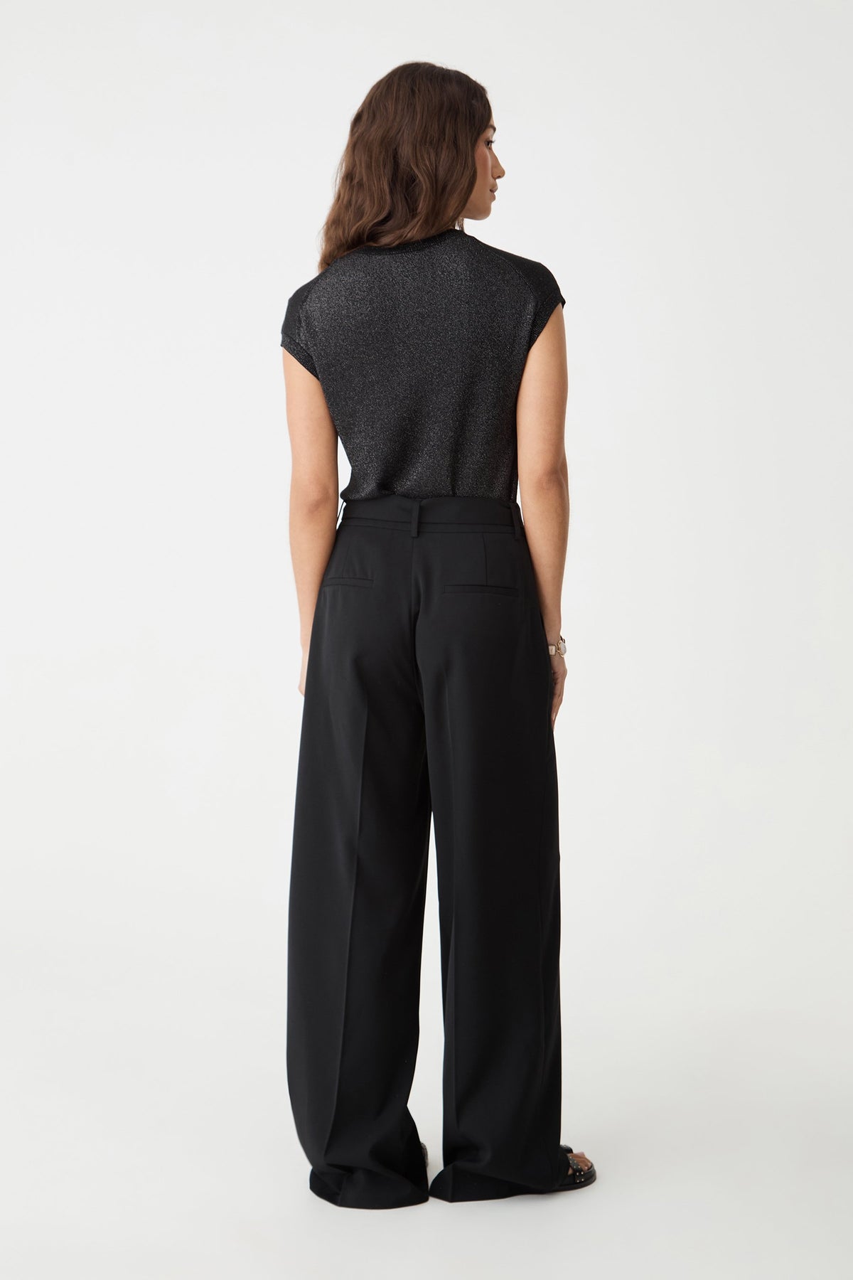 Back view of the black wide leg pants showing back welt pockets and full-length hem