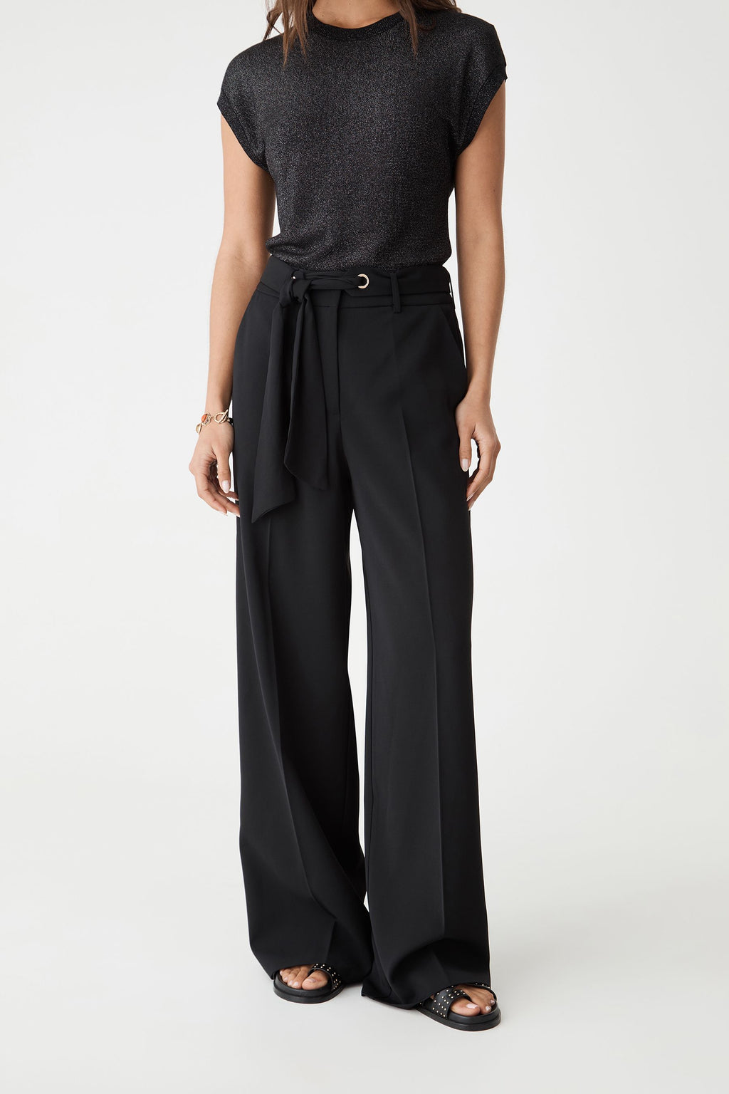 Close-up front view of the black wide leg pants showing the tied scarf belt and side pockets