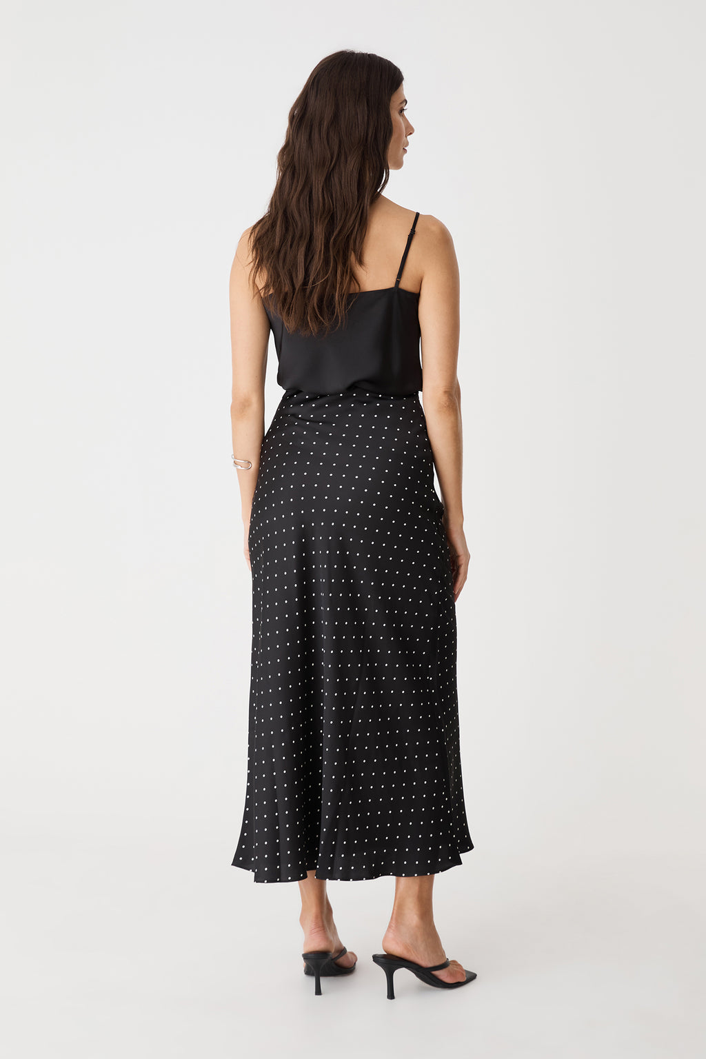 Back view of the Courtney Bias Satin Skirt in black and white dot