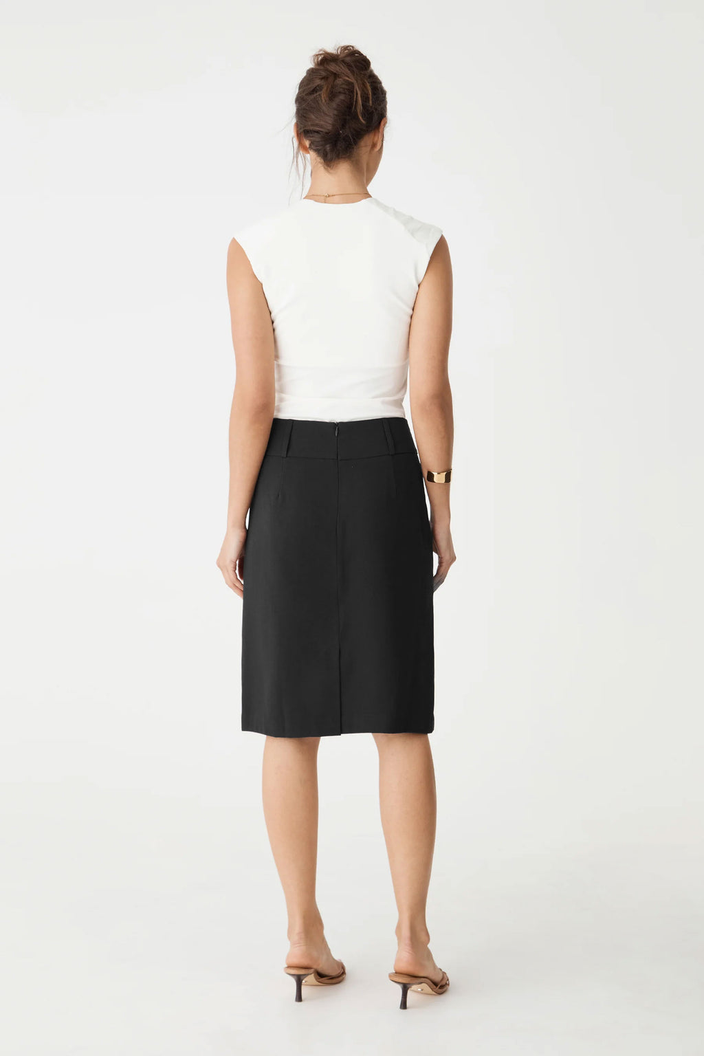 Back view showing the centre-back zip and vent of the black midi skirt