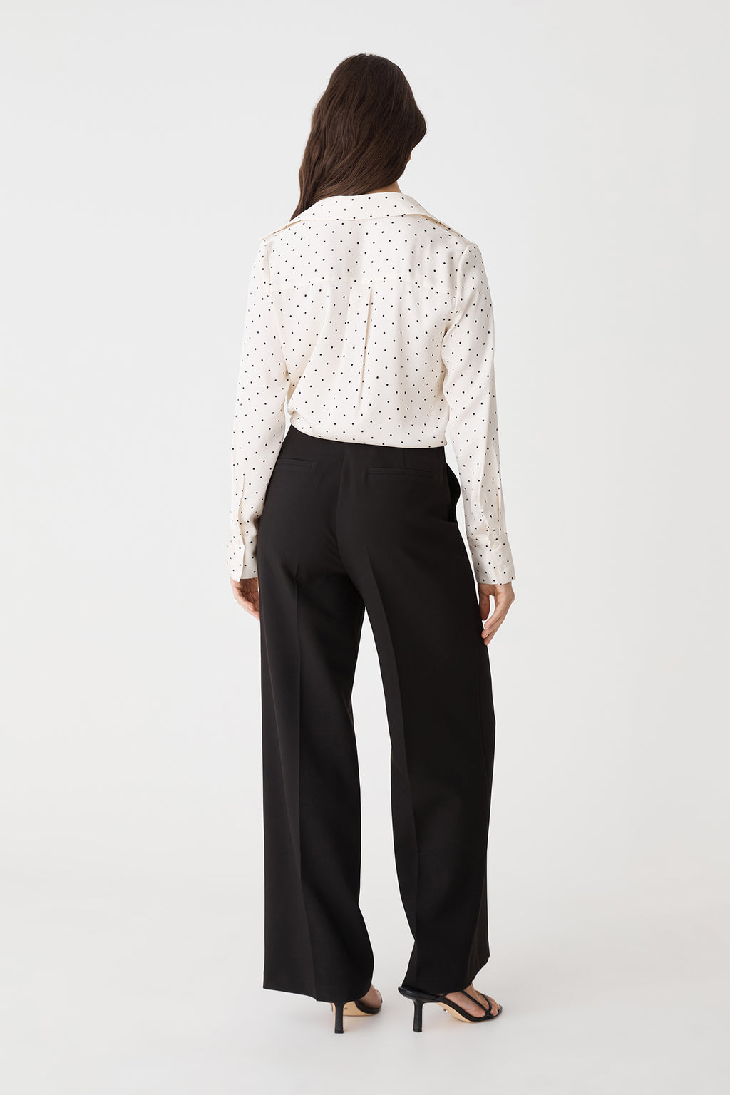 Back view of the Courtney Satin Spot Shirt in Ivory & Black Dot with black trousers