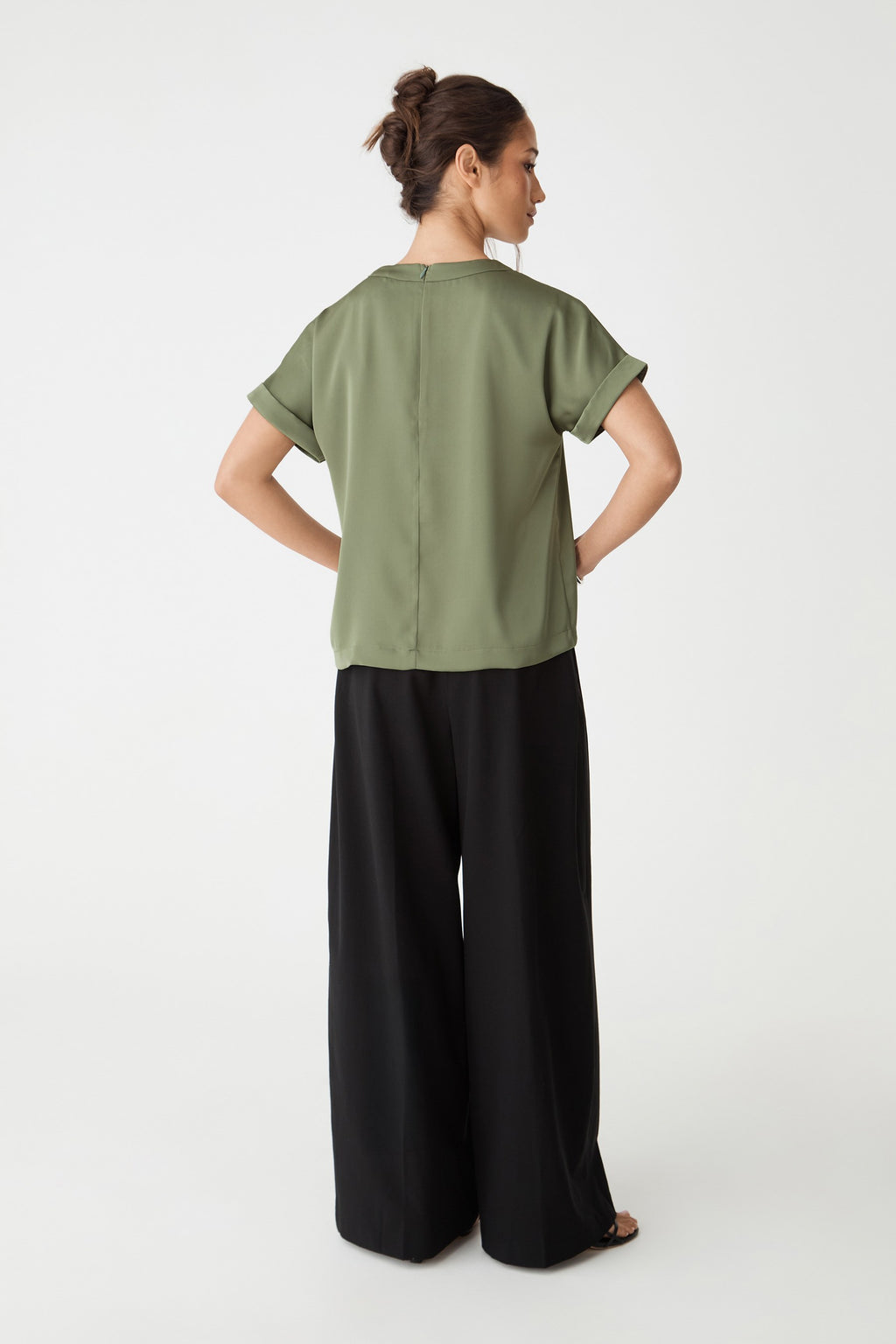 Back view showing boxy shape and invisible back zipper, worn with black trousers