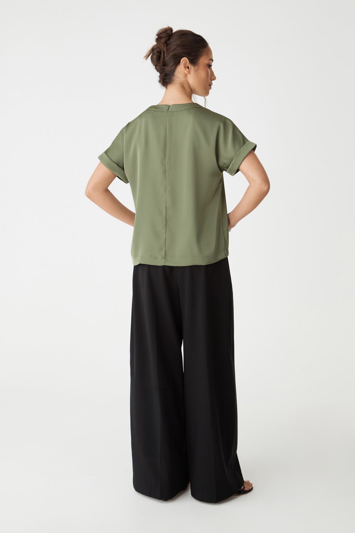 Back view showing boxy shape and invisible back zipper, worn with black trousers