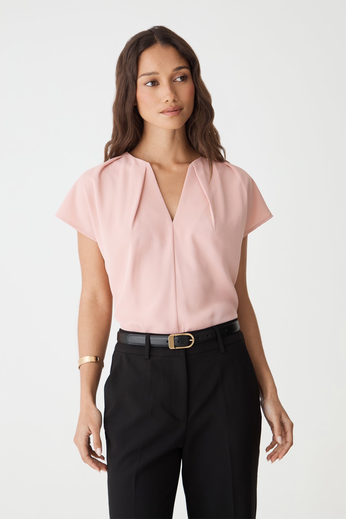 Jane Pleated Neck Top in Pink Sand, front view with split V-neckline and cap sleeves, worn with black trousers