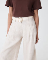 Elena Crochet Belt in ivory with round gold-tone buckle, worn at the waist with linen trousers and brown tee
