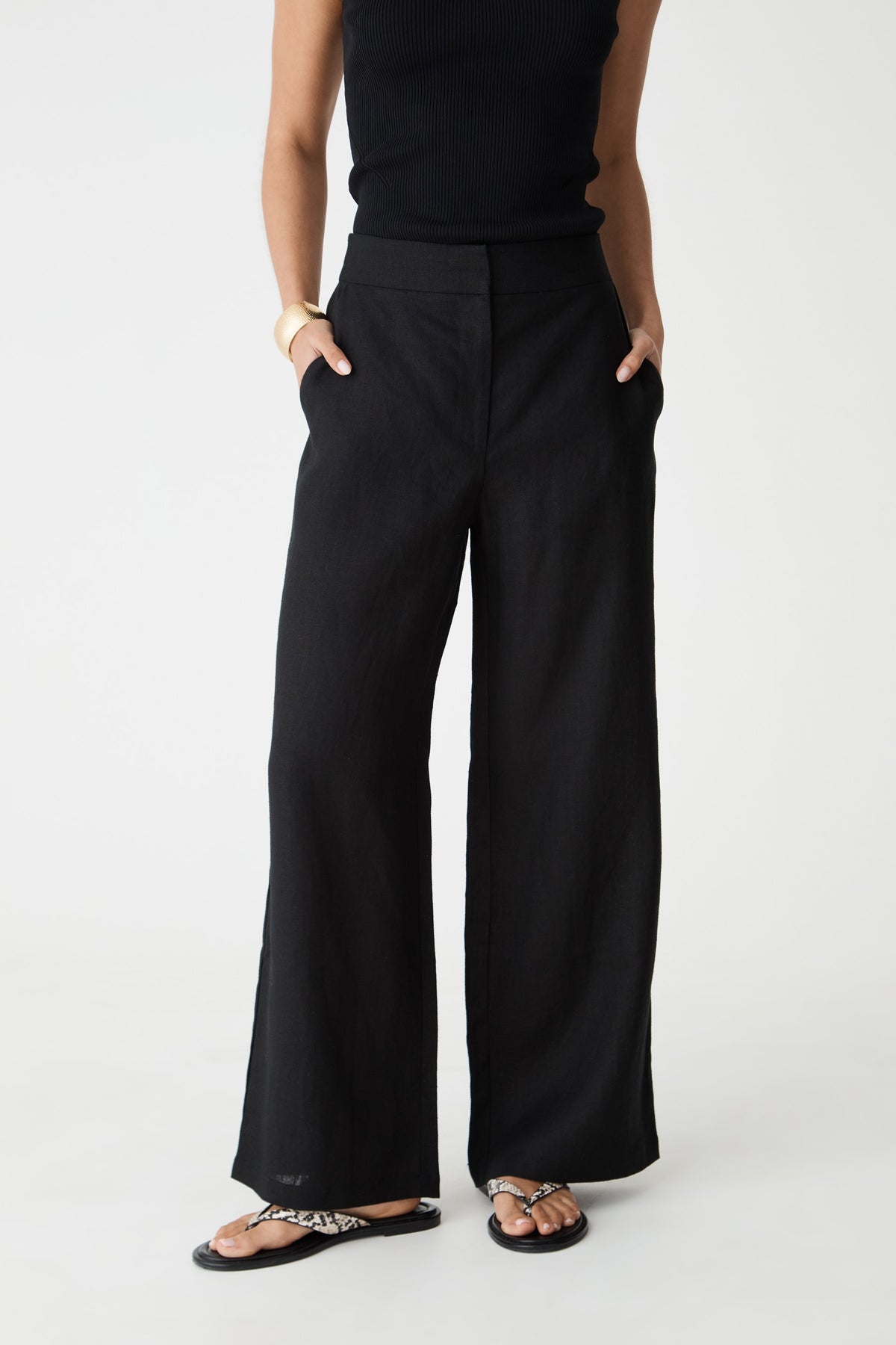 Close-up front view of the black wide-leg linen pants showing high rise waist and side pockets