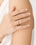 Julee Wave Ring in gold worn on the ring finger, hand resting on arm